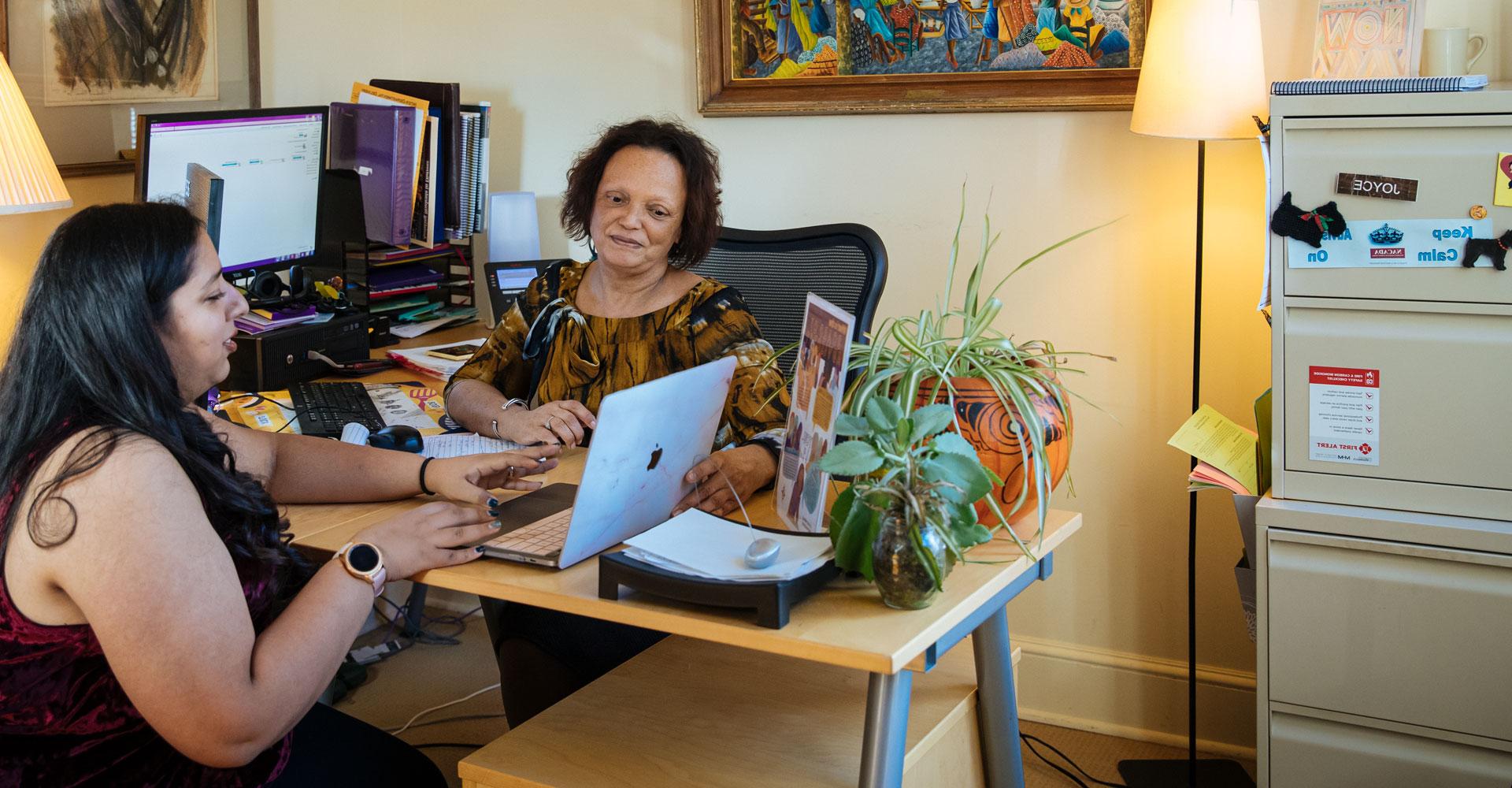 A student speaking with an Agnes Scott Summit advisor in an office.